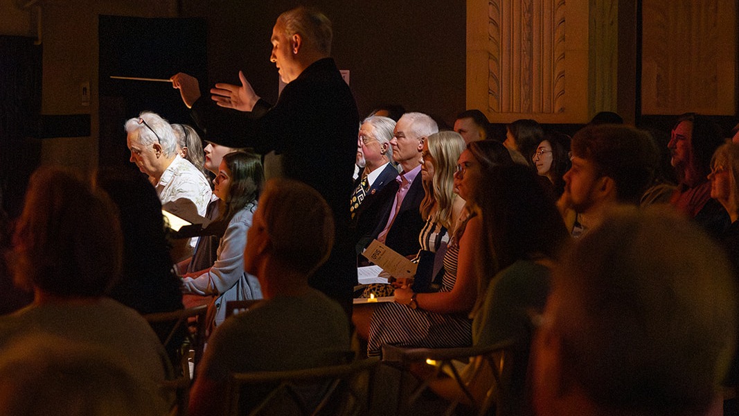 Joshua Oppenheim conducting with baton