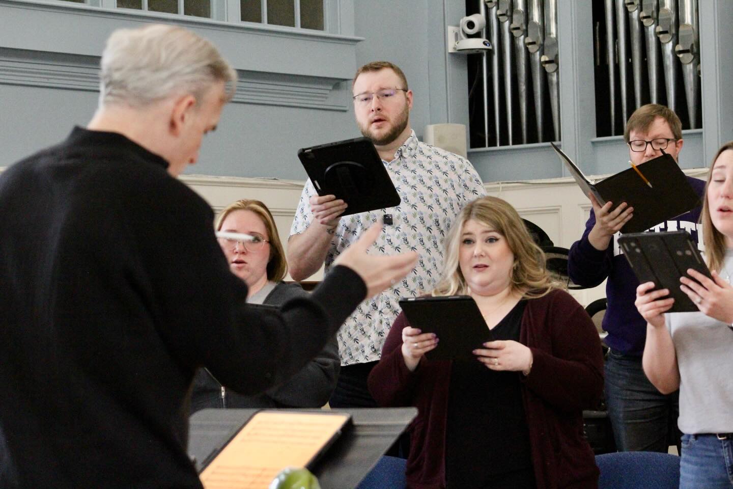 Joshua Oppenheim rehearsing with choir near an organ